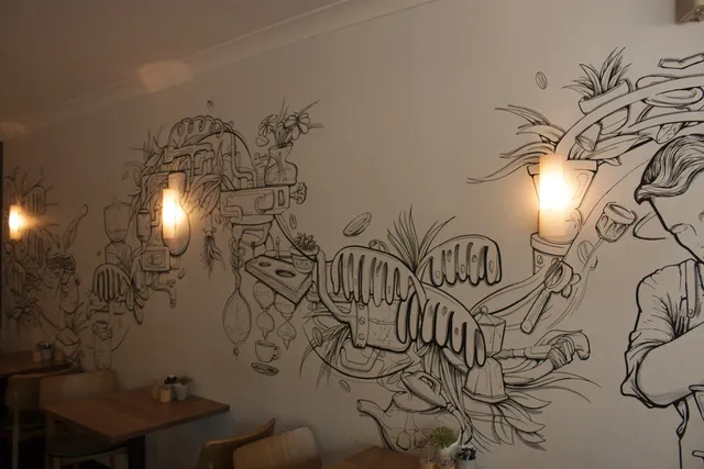 wall lights illuminating interior mural at cafe