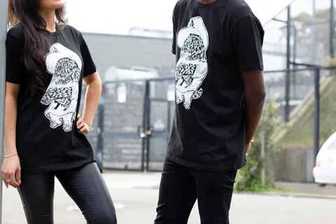 Two people wearing black t-shirts featuring a white line illustration of a hip-hop dog in a bucket hat