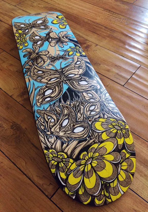 Closeup of finished hand painted skateboard graphic with butterflies and flowers.