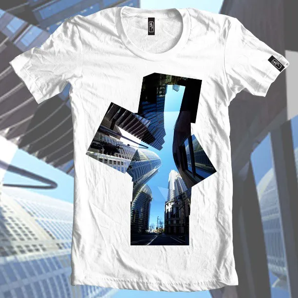White t-shirt printed with an abstract geometric shape containing a photo of skyscrapers reaching into a blue sky