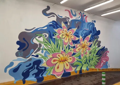 Mural of three stylized pink and yellow flowers with green leaves against flowing abstract blue and purple shapes