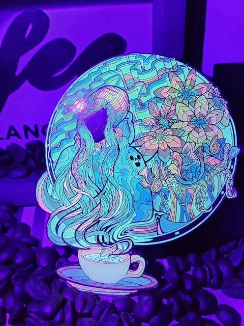 UV-reactive enamel pin of a figure with flowing hair emerging from a coffee cup amidst psychedelic flowers