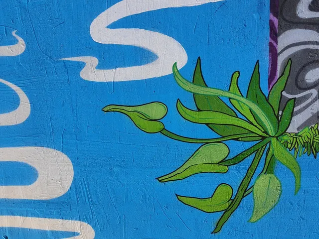 Mural detail of stylized green leaves and white wavy lines painted on a textured bright blue background