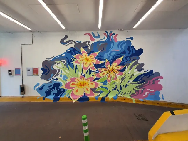 Carpark mural of three stylized pink and yellow flowers among green leaves and swirling blue abstract shapes