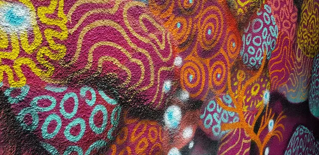 Psychedelic abstract mural detail featuring organic coral-like patterns in bright pink, orange, yellow and turquoise
