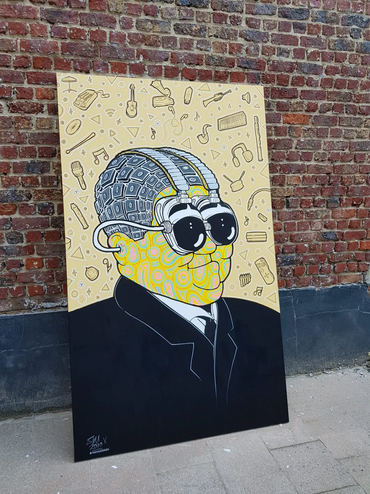 Painted panel of a suited man with a patterned yellow face and goggles, surrounded by floating audio gear and instruments