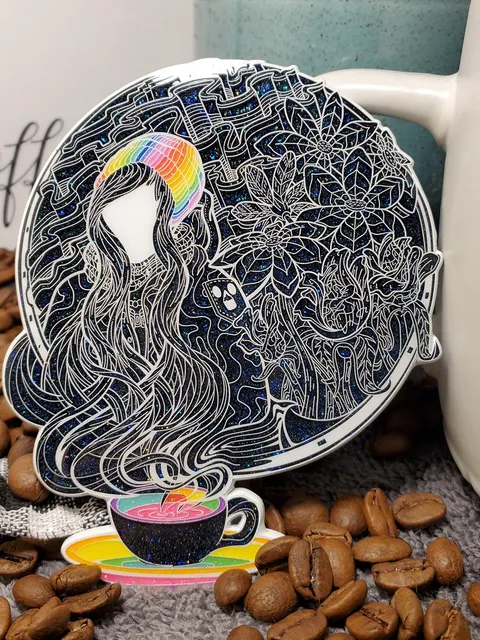 Glitter sticker of a faceless figure in a rainbow beanie with flowing hair and white floral line art above a coffee cup
